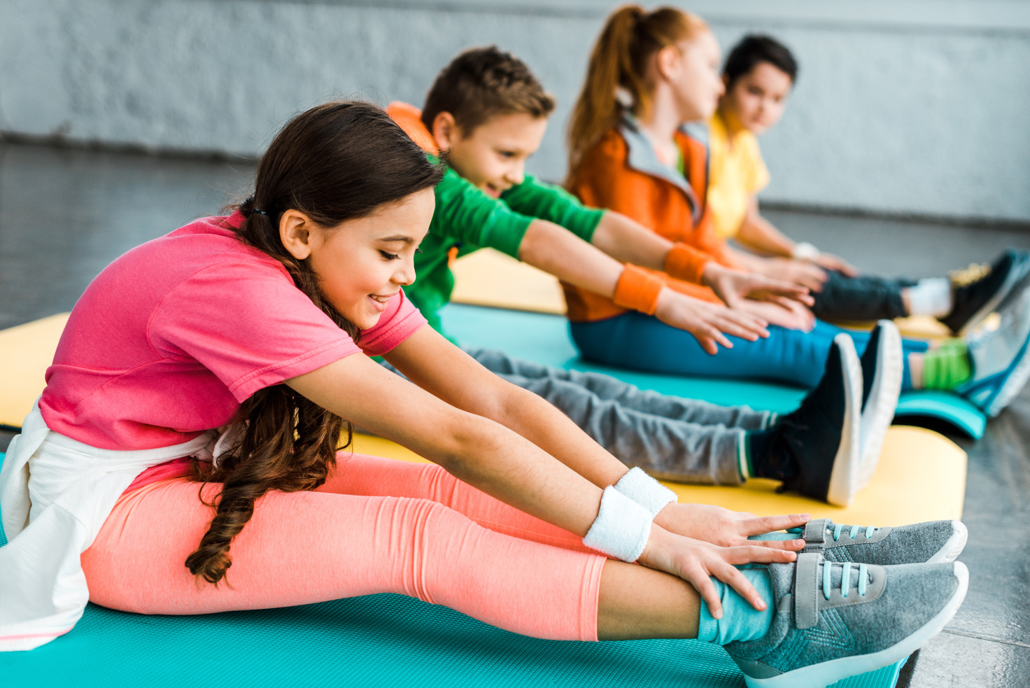 Group of kids stretching in gym together